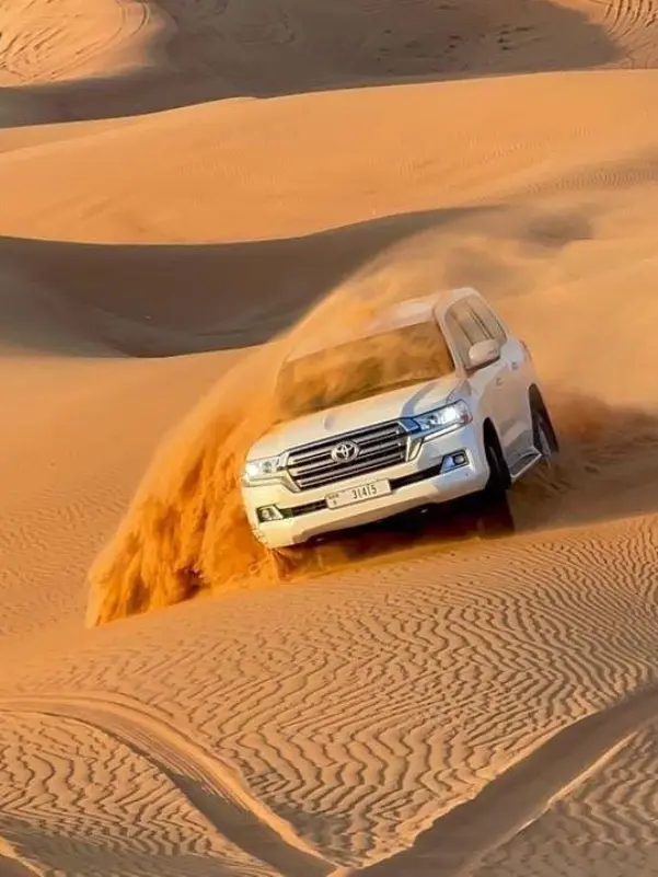 Car driving through sandy desert
