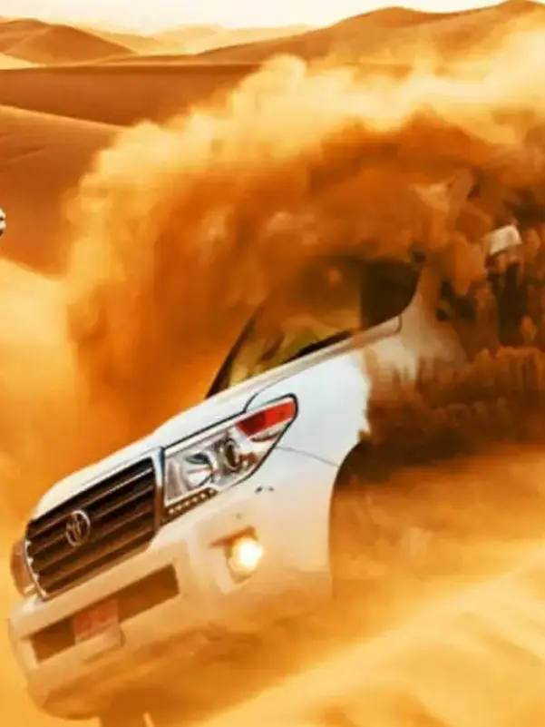 White SUV driving through sand