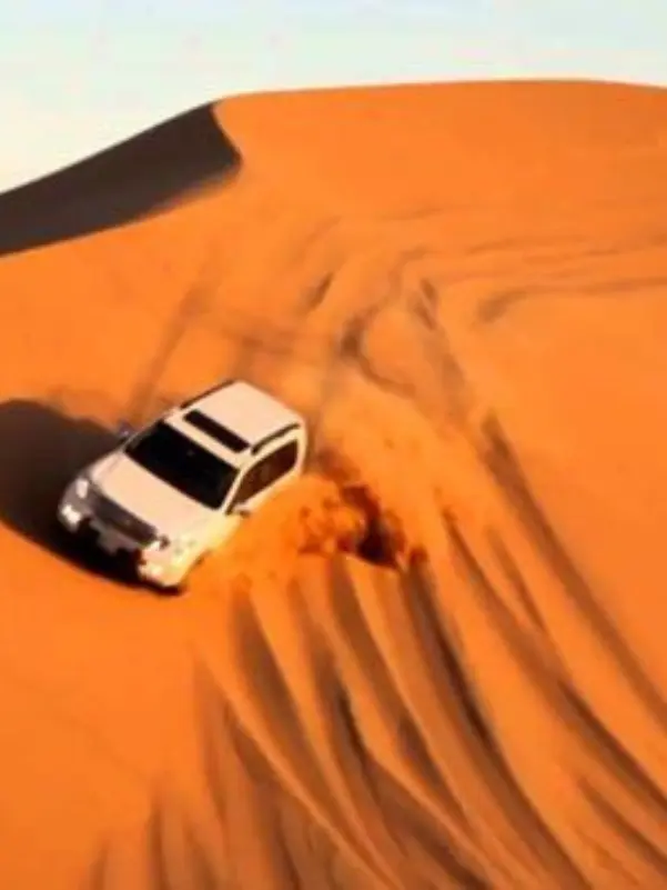 Car driving on sandy dune