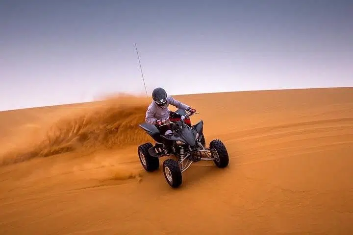 Quad biking experience during Sunrise Desert Safari Dubai in red dunes