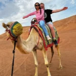 Couple riding a camel in desert