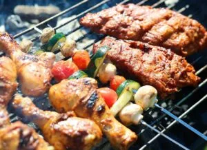 Chicken, kebab skewers and vegetables on a barbecue grill