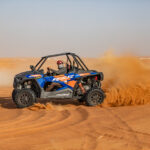 ATV racing through sandy desert terrain