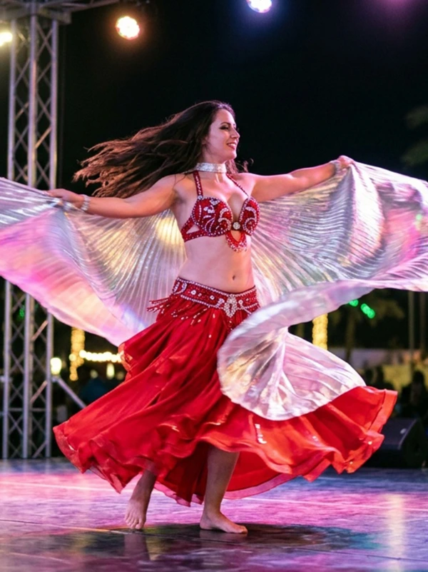 Belly dancer in a red costume performing live at a Dubai desert safari camp