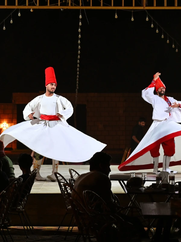 Tanoura whirling dance show in traditional white costumes at Desert Safari Dubai