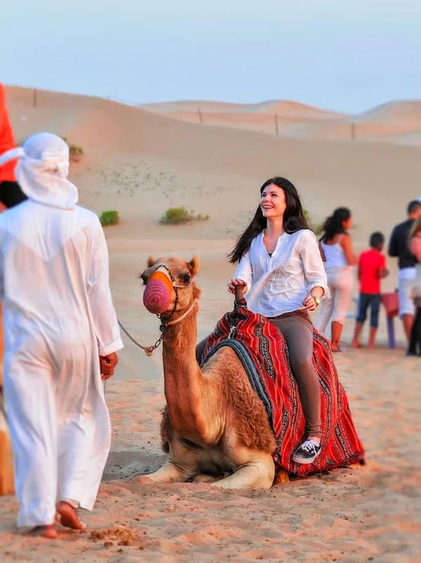 Visitors enjoying a camel ride across the Lahbab desert in Dubai
