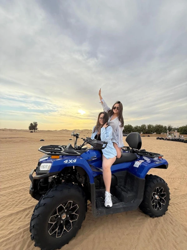Friends on a quad bike at sunset during a Desert Safari Dubai adventure